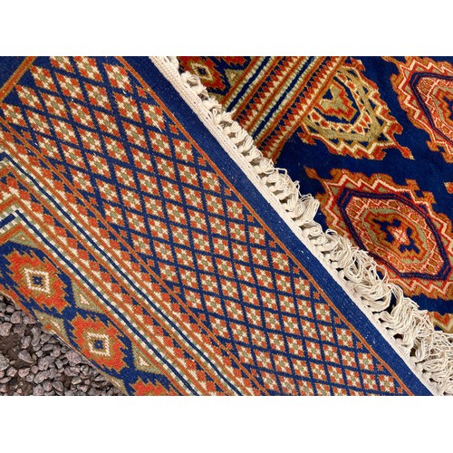 97 - GOOD QUALITY GEOMETRIC PATTERN FRINGED CARPET ON BLUE GROUND 188cm x 120cm