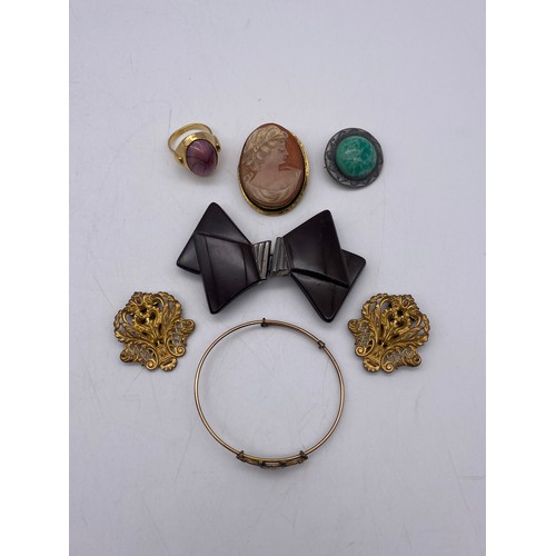 751 - PAIR OF GILT METAL CLIPS, CARVED CAMEO BROOCH, CABOCHON STONE SET DRESS RING AND AN UNMARKED GILT BA... 