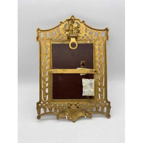 484 - GILT METAL CHERUB MOUNTED MIRROR WITH CANDLE BRANCHES MISSING A/F