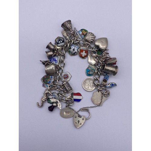 527 - SILVER CHARM BRACELET WITH HEART PADLOCK AND FASTENER, VARIOUS SILVER AND WHITE METAL CHARMS 2OZ APP... 