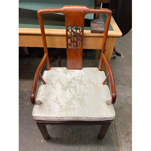 74 - CHINESE INFLUENCE CARVED ROSEWOOD EFFECT EXTENDING DINING TABLE AND EIGHT CHAIRS WITH LOOSE CUSHIONS