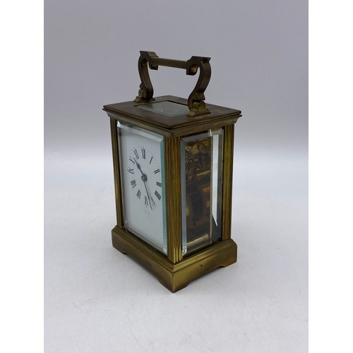 550 - TWO SIMILAR BRASS LAQUERED CARRIAGE CLOCKS WITH ANGULAR HANDLES