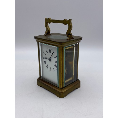 550 - TWO SIMILAR BRASS LAQUERED CARRIAGE CLOCKS WITH ANGULAR HANDLES