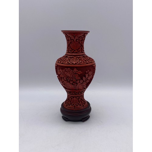 551 - RED CINNABAR LACQUER CARVED BALUSTER VASE ON A HARD WOOD STAND