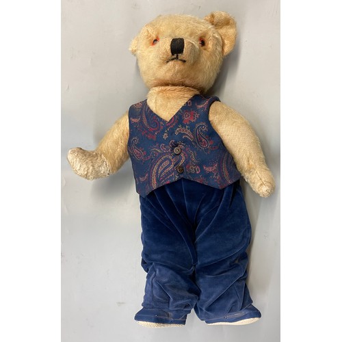 299 - PLUSH MO HAIR MID 20TH CENTURY TEDDY BEAR DRESSED IN WAISTCOAT AND VELVET TROUSERS