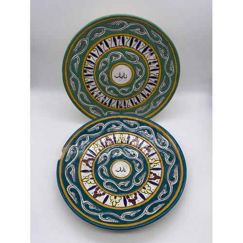 650 - PAIR OF MID CENTURY IRANIAN POTTERY DECORATED WALL PLATES (ONE A/F)