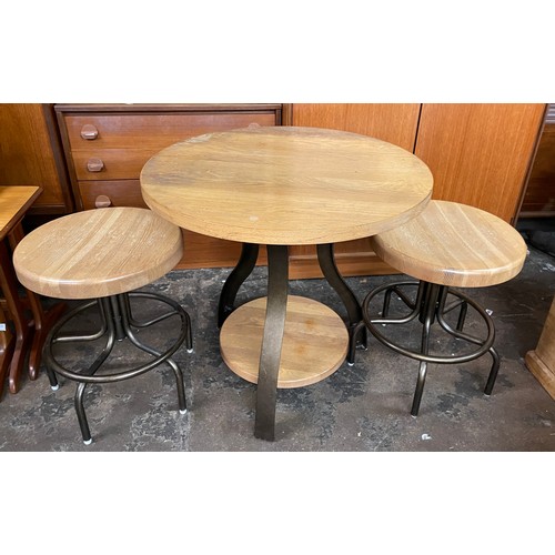 112 - SMALL CIRCULAR CROSS STRETCHER TABLE AND PAIR OF INDUSTRIAL STOOLS