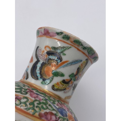 520 - SMALL FAMILLE ROSE BALUSTER VASE DECORATED WITH BUTTERFLIES 14CM H