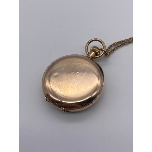 569 - 9CT ROSE GOLD CASED POCKET WATCH WITH ROMAN NUMERAL DIAL ON A 9CT GOLD CHAIN 30.7G OVERALL