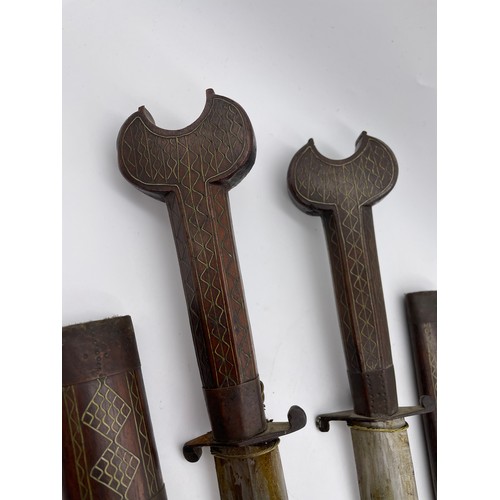 485 - PAIR OF EASTERN ROSE WOOD AND BRASS INLAID DECORATIVE DAGGERS