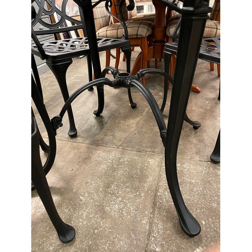 76 - BLACKENED CAST METAL CIRCULAR PATIO TABLE AND FOUR ARMCHAIRS