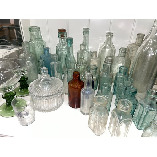 389 - QTY OF CLEAR GREEN AND BLUE GLASS CHEMIST BOTTLES AND JARS, SODA BOTTLES, AND ADVERTISING WARES