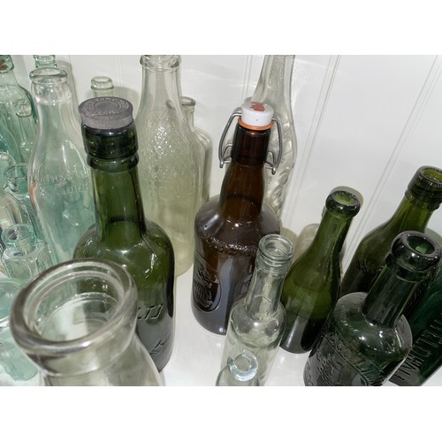 389 - QTY OF CLEAR GREEN AND BLUE GLASS CHEMIST BOTTLES AND JARS, SODA BOTTLES, AND ADVERTISING WARES