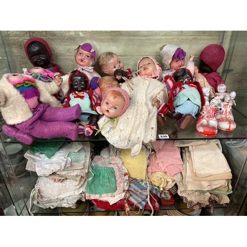 235 - TWO SHELVES OF MID 20TH CENTURY DOLLS AND DOLLS CLOTHING