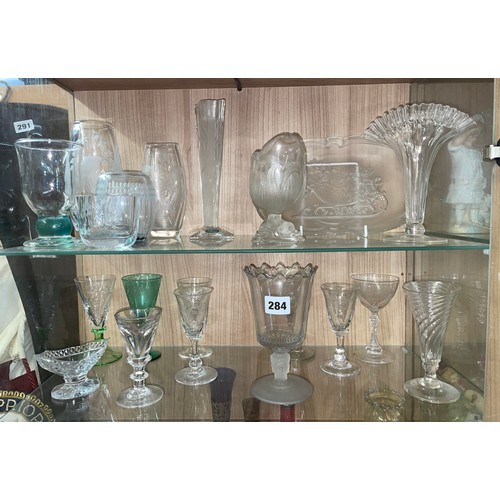 284 - TWO SHELVES OF ANTIQUE AND LATER CUT AND PRESSED GLASSWARE INCLUDING PEDESTAL SALT, SPILL VASES, GOB... 