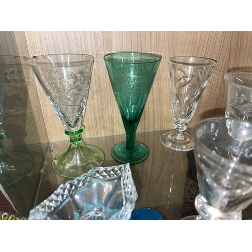 284 - TWO SHELVES OF ANTIQUE AND LATER CUT AND PRESSED GLASSWARE INCLUDING PEDESTAL SALT, SPILL VASES, GOB... 