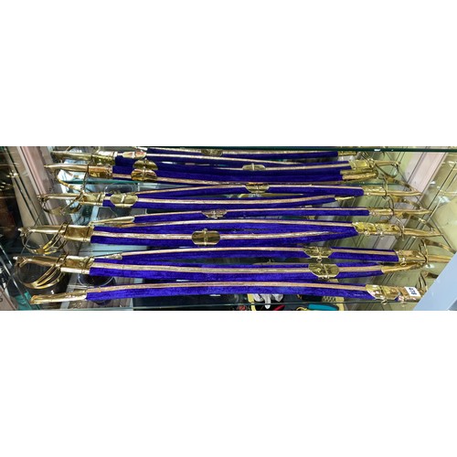 478 - NINE BRASS MOUNTED INDIAN CEREMONIAL SWORDS IN PURPLE SCABBARDS