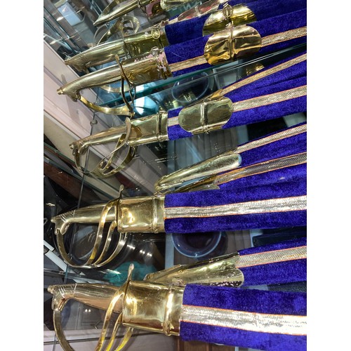 478 - NINE BRASS MOUNTED INDIAN CEREMONIAL SWORDS IN PURPLE SCABBARDS