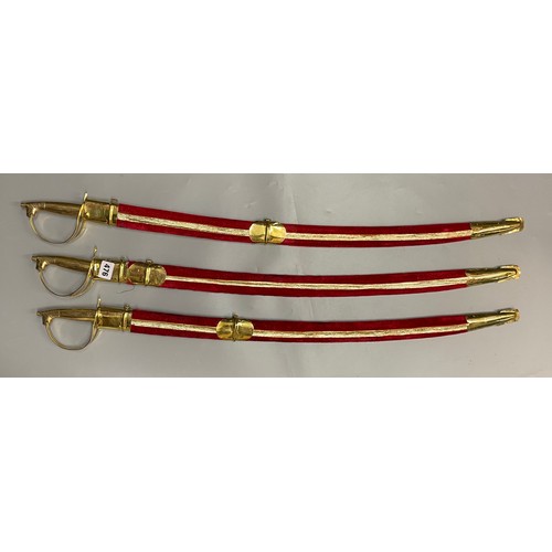 476 - THREE BRASS MOUNTED INDIAN CEREMONIAL SWORDS IN RED SHEATH SCABBARD