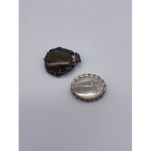 573 - SILVER MOUNTED POLISHED AGATE BROOCH AND SILVER MOTHER OF PEARL BROOCH