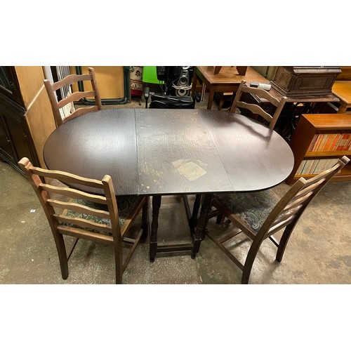 71 - OVAL DARKWOOD DROP FLAP TABLE AND FOUR LADDER BACK CHAIRS