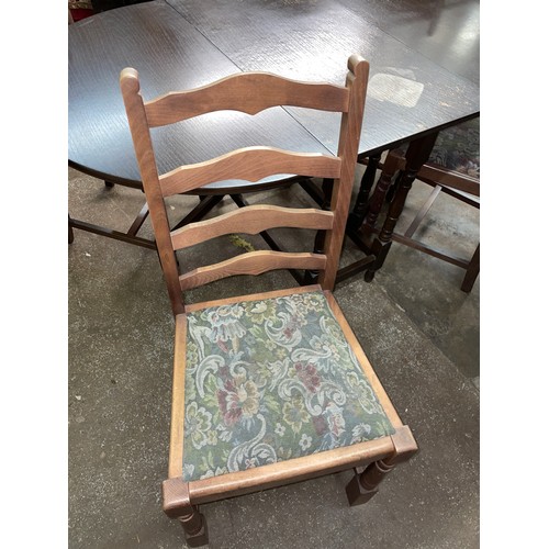 71 - OVAL DARKWOOD DROP FLAP TABLE AND FOUR LADDER BACK CHAIRS