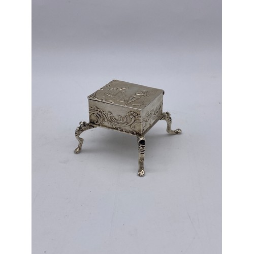 462 - IMPORTED LONDON SILVER MINIATURE RAISED SQUARE SECTION TRINKET BOX HINGE A/F DECORATED WITH COURTING... 