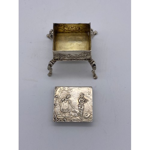 462 - IMPORTED LONDON SILVER MINIATURE RAISED SQUARE SECTION TRINKET BOX HINGE A/F DECORATED WITH COURTING... 