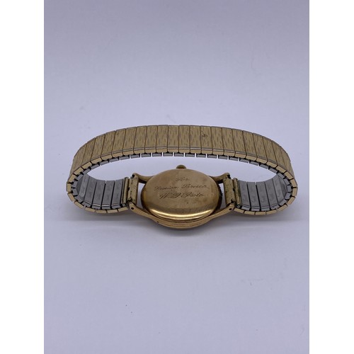 560 - 9CT GOLD CASED GARRARD WRISTWATCH ON PLATED BARK EFFECT ELASTICATED STRAP