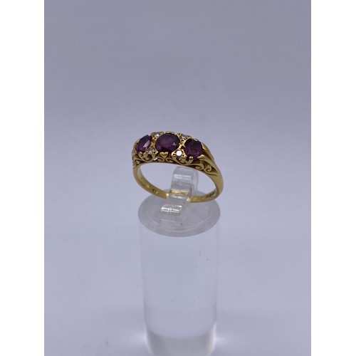 567 - 18CT GOLD THREE STONE RUBY AND DIAMOND GYPSY STYLE RING 4.6G APPROX