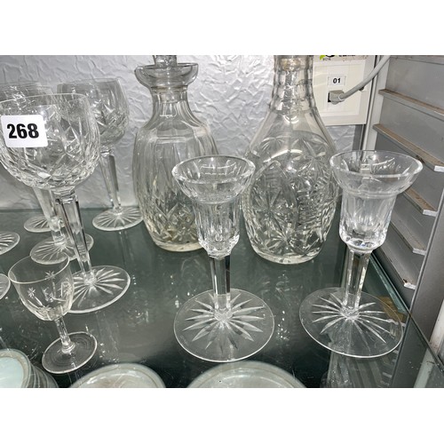 268 - SHELF CONTAINING WATERFORD CANDLE HOLDERS, CUT GLASS WINE FLUTES, AND TWO DECANTERS