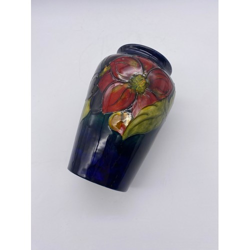 493 - MOORCROFT POTTERY CLEMATIS PATTERN TAPERED VASE ON DARK BLUE GROUND