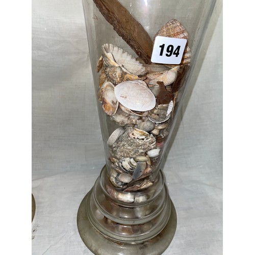 194 - PAIR OF TALL TAPERED GLASS JARS WITH LIDS WITH SPIRE FINIALS CONTAINING SHELLS AND DRIFTWOOD