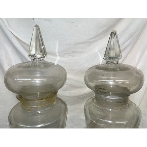 194 - PAIR OF TALL TAPERED GLASS JARS WITH LIDS WITH SPIRE FINIALS CONTAINING SHELLS AND DRIFTWOOD