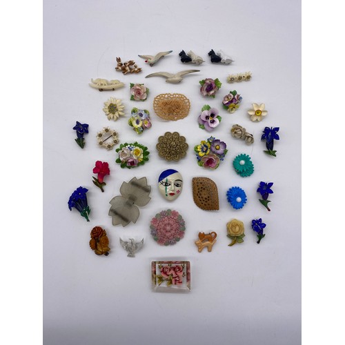 599 - TRAY OF PORCELAIN FLORAL ENCRUSTED PLASTIC AND LUCITE BROOCHES AND BUCKLES