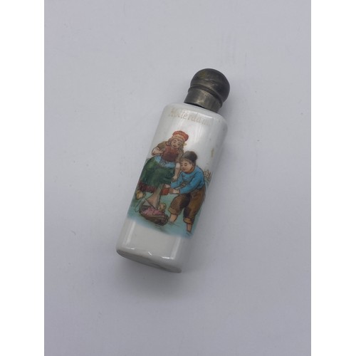 226 - THREE PORCELAIN BASE METAL TOPPED CYLINDRICAL AND SHAPED SCENT PHIALS WITH DUTCH BOY AND GIRL DECORA... 