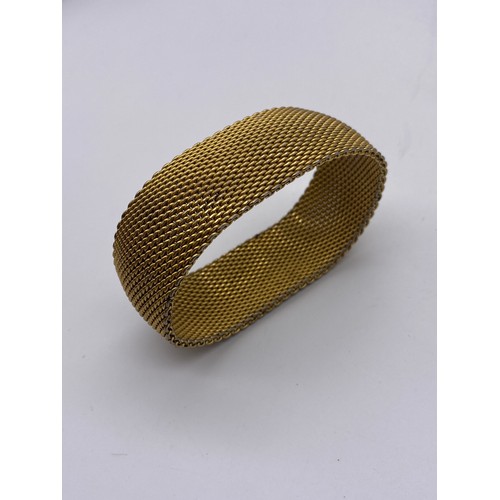 465 - TWO GOLD COLOURED BRACELETS AN ELASTICATED MESH BANGLE, AND MONET PLATED NECK CHAIN