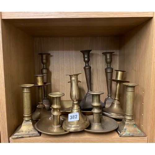 382 - PIGEONHOLE OF BRASS CHAMBER STICKS AND PAIRS OF BRASS CYLINDRICAL AND TAPERED CANDLE STICKS