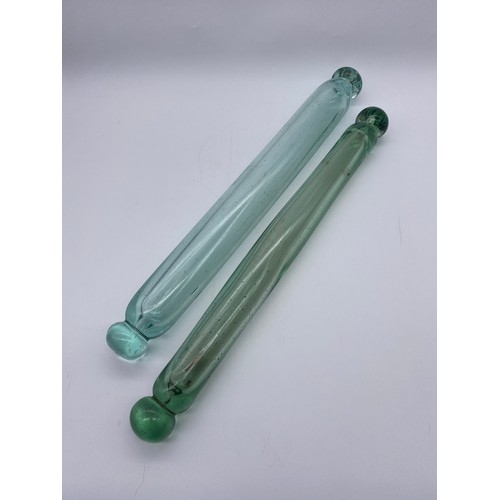 853 - TWO VICTORIAN GREEN TINTED GLASS ROLLING PINS ONE CONTAINING A VICTORIAN COIN