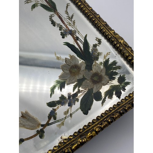 858 - GILT METAL ARCH FRAMED MIRROR WITH PAINTED FLORAL DECORATION