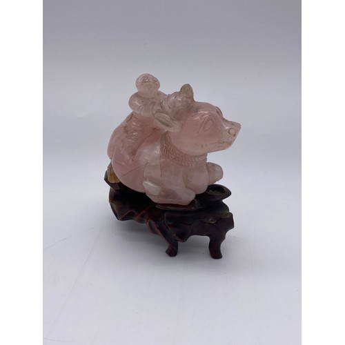 774 - CHINESE ROSE QUARTZ CARVING OF A BOY ASTRIDE A WATER BUFFALO ON STAND A/F