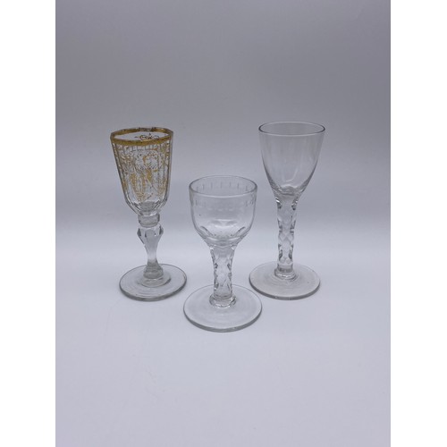 874 - TWO FACET CUT STEMMED WINE GLASSES AND A 19TH CENTURY GILT DECORATED WINE GLASS