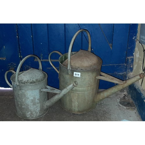 211 - TWO GALVANISED WATERING CANS AND A DOLLY PUSHER