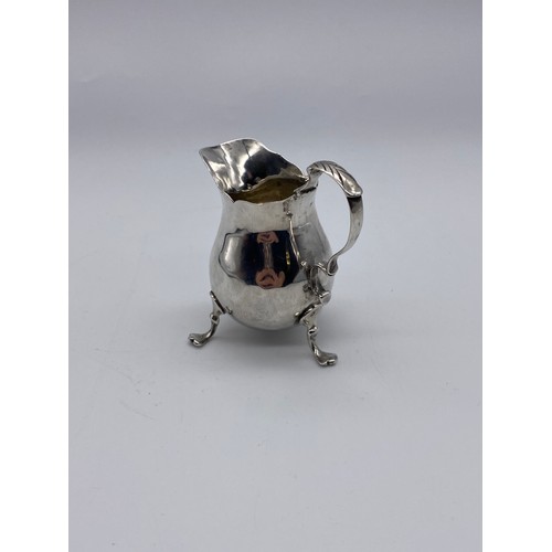 465 - GEORGIAN LONDON SILVER CREAM JUG WITH SCROLL HANDLE RAISED ON PAD FEET (MARKS INDISTINCT) 2.3OZ APPR... 