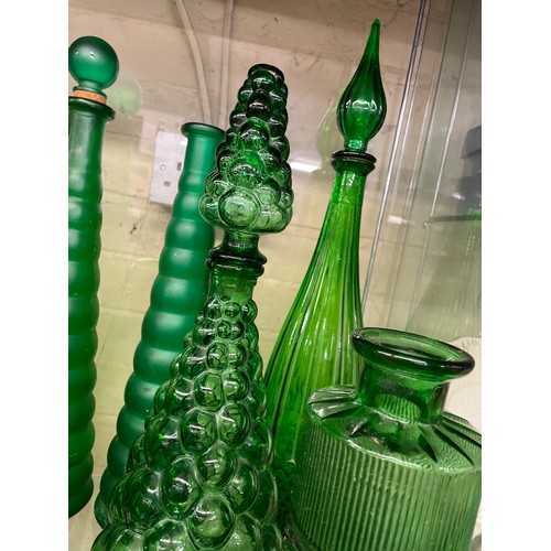 432 - SHELF OF GREEN PRESSED GLASS GENIE BOTTLES INC. EMPOLI AND A LEANING KLUK KLUK DECANTER (SOME WITH S... 