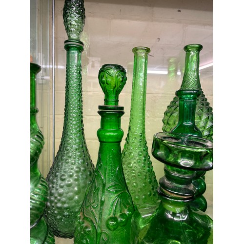 432 - SHELF OF GREEN PRESSED GLASS GENIE BOTTLES INC. EMPOLI AND A LEANING KLUK KLUK DECANTER (SOME WITH S... 