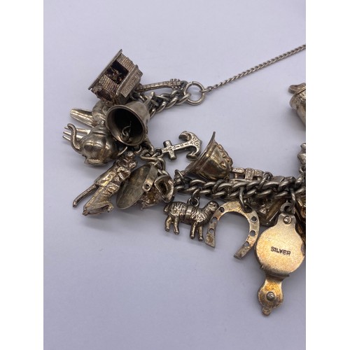 530 - SILVER CHARM BRACELET WITH HEART PADLOCK AND VARIOUS NOVELTY CHARMS 93G APPROX