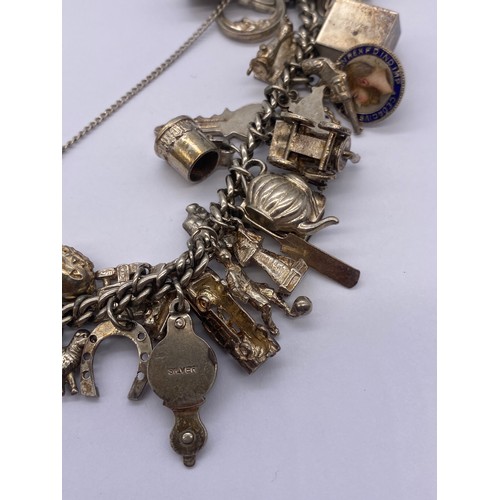 530 - SILVER CHARM BRACELET WITH HEART PADLOCK AND VARIOUS NOVELTY CHARMS 93G APPROX