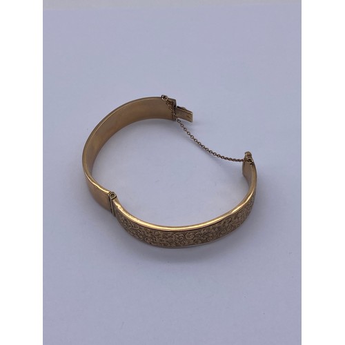 556 - 9CT GOLD ENGRAVED CUFF BANGLE WITH SAFETY CHAIN 14.2G APPROX