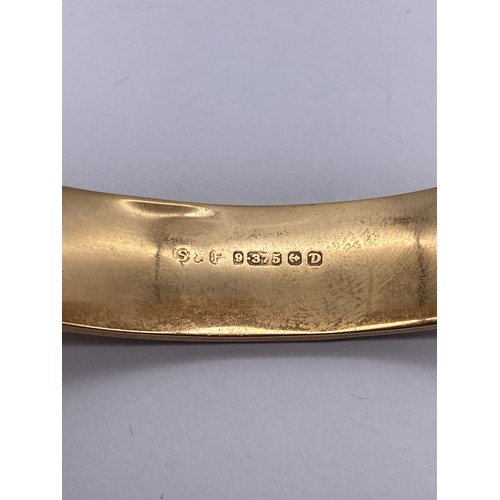 556 - 9CT GOLD ENGRAVED CUFF BANGLE WITH SAFETY CHAIN 14.2G APPROX